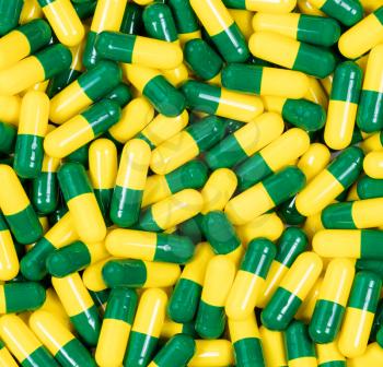 Filled frame of medicine capsules in green and yellow colors.