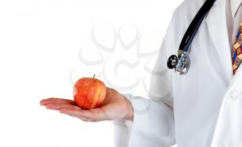 Partial side view of doctor holding apple in hand while wearing jacket with stethoscope on white background.  