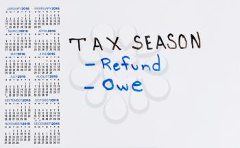 Calendar on white board with tax concept for either a refund or owe.  