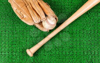 Overhead view of baseball mitt, ball and bat on artificial grass 