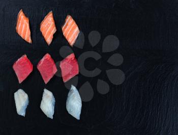 Overhead view of fresh Japanese sushi on black slate. Horizontal layout with plenty of copy space. 