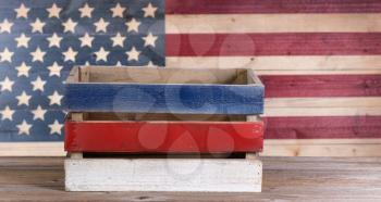 Wooden crate with vintage wooden USA flag in background.