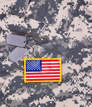 USA flag patch, ID tags on military battle dress uniform. 