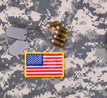 USA flag patch, ID tags, bullets on military battle dress uniform. 

