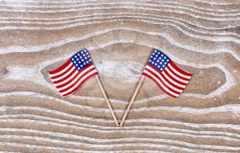 Small USA flags on white rustic wood. Fourth of July holiday concept for United States of America.  