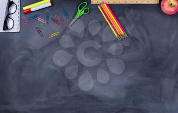 Back to school concept with student supplies on upper part of chalkboard.