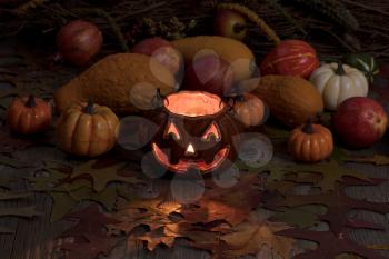 Glowing pumpkin decoration in darkness on rustic wood with autumn leaves and gourds