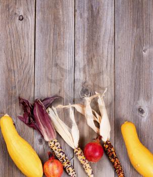 Overhead view of seasonal autumn vegetable decorations on rustic wooden boards. Vertical layout. 