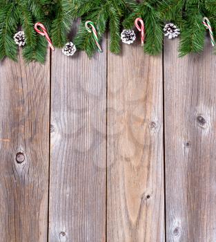 Christmas holiday wooden background with fir branches and candy canes. 