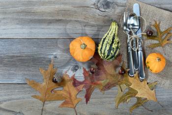 Overhead view of dinner setting for Thanksgiving Autumn holiday in horizontal layout on rustic wooden boards. 