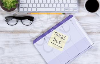 Tax concept with calendar reminder, and other desktop work supplies.