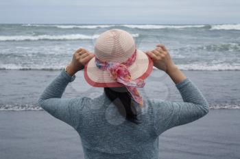 Woman looking at waves on Pacific Ocean 