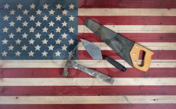Labor Day background with USA rustic wooden flag and used industrial tools 