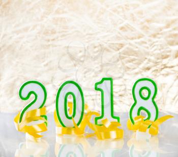 2018 New Year numbers and yellow ribbons on bright golden background