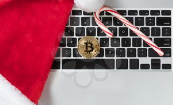 Golden Bitcoin on top computer keyboard during Christmas holiday shopping season 