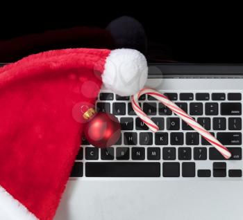 Santa Claus hat and candy cane on top computer keyboard during Christmas holiday shopping season 