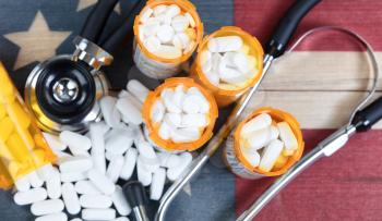 Top view of full prescription bottles with stethoscope and pills on rustic wooden United States background 