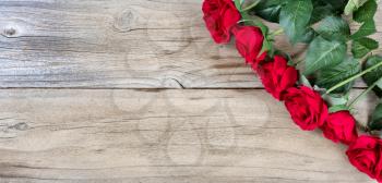 red roses on weathered wooden background in flat lay view 