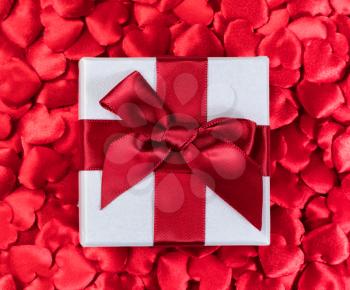 Valentines gift box with red hearts in background 