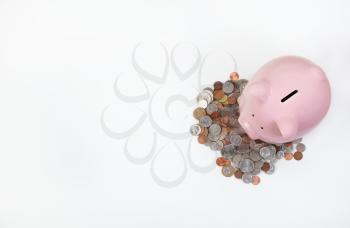 Piggy Bank and coins on white desktop with copy space