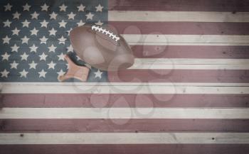 American football and kick tee on vintage United States wooden flag