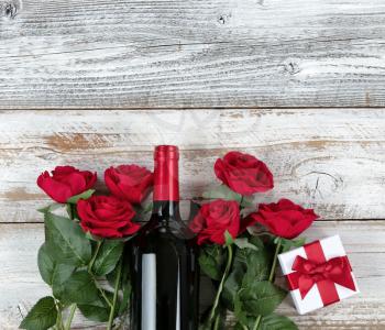 Romantic Valentines Day celebration with red wine and gifts in bottom of white rustic wood 
