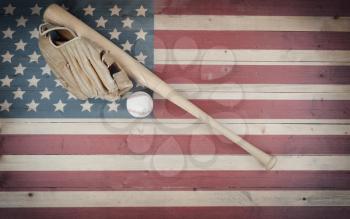Old American baseball equipment on vintage United States wooden flag