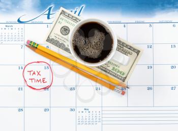 Tax due date marked on calendar with pencils and coffee on top 
