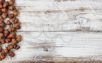 Autumn decorations with real acorns on white rustic wooden boards for Halloween or Thanksgiving holiday concept