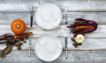 White dinner table decorated for Thanksgiving celebration in overhead view 