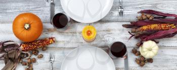 White rustic dinner table prepared for Thanksgiving celebration in overhead view 