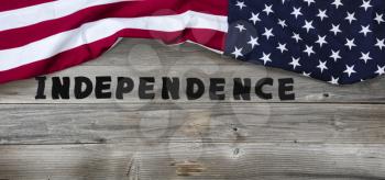 United States of America flag forming upper border on rustic wooden boards with large text letters for Independence concept  