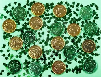 Saint Patricks Day with shamrocks and shiny coins on green background in filled frame format 