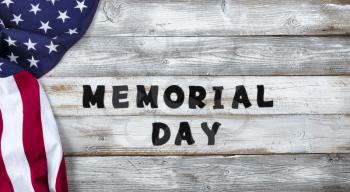 Waving United States Flag on left side of white rustic wooden with large text for Memorial Day Background  