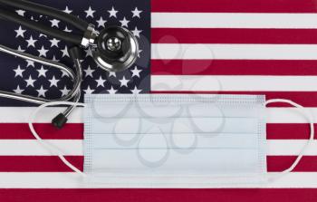 Medical stethoscope and protective mask with United States flag as background 