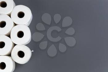 Toilet paper rolls on gray background. Overhead flat lay format with copy space. Hoarding concept for Coronavirus fear. 