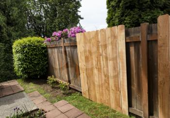 New cedar fence boards being installed against old existing ones