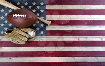 American baseball and football equipment on vintage wooden US flag background. USA sports concept with copy space