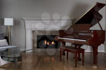 Glowing fireplace with baby grand piano on solid red oak floors  