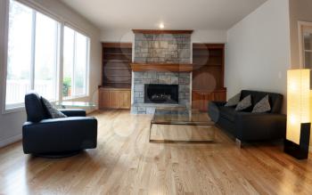  Family room remodeled with solid red oak wooden floors and new furniture. Gas insert fireplace operating in background. 