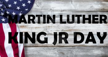 Waving United States Flag on left side of white rustic wooden Background with Martin Luther King text message