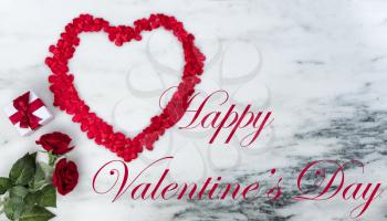 Happy Valentines Day with lovely red outline shape of large heart and romantic gifts on natural marble stone background plus text message 