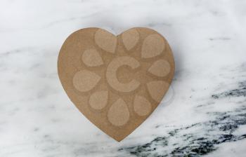 A large cardboard heart giftbox for Happy Valentines Day  on a marble stone background   