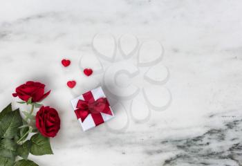 Happy Valentines Day with lovely red rose flowers plus giftbox on natural marble stone background 