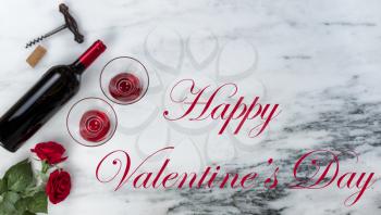 Red wine and corkscrew opener for a Happy Valentines Day on marble stone background setting with text message 