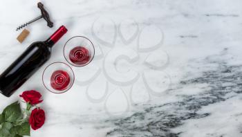 Red wine and corkscrew opener for a Happy Valentines Day on marble stone background setting  