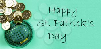 St Patricks day Irish elf hat and gold coins on a green paper background with copy space plus text message 
