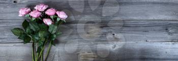 Overhead view of pink roses on rustic wood for Mothers Day concept 