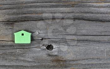 Miniature house key holder on vintage wooden plank background 