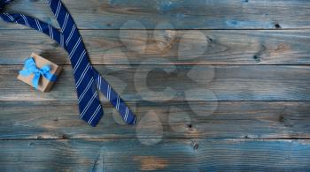 Neck tie and giftbox on faded blue wood for happy fathers day concept background 